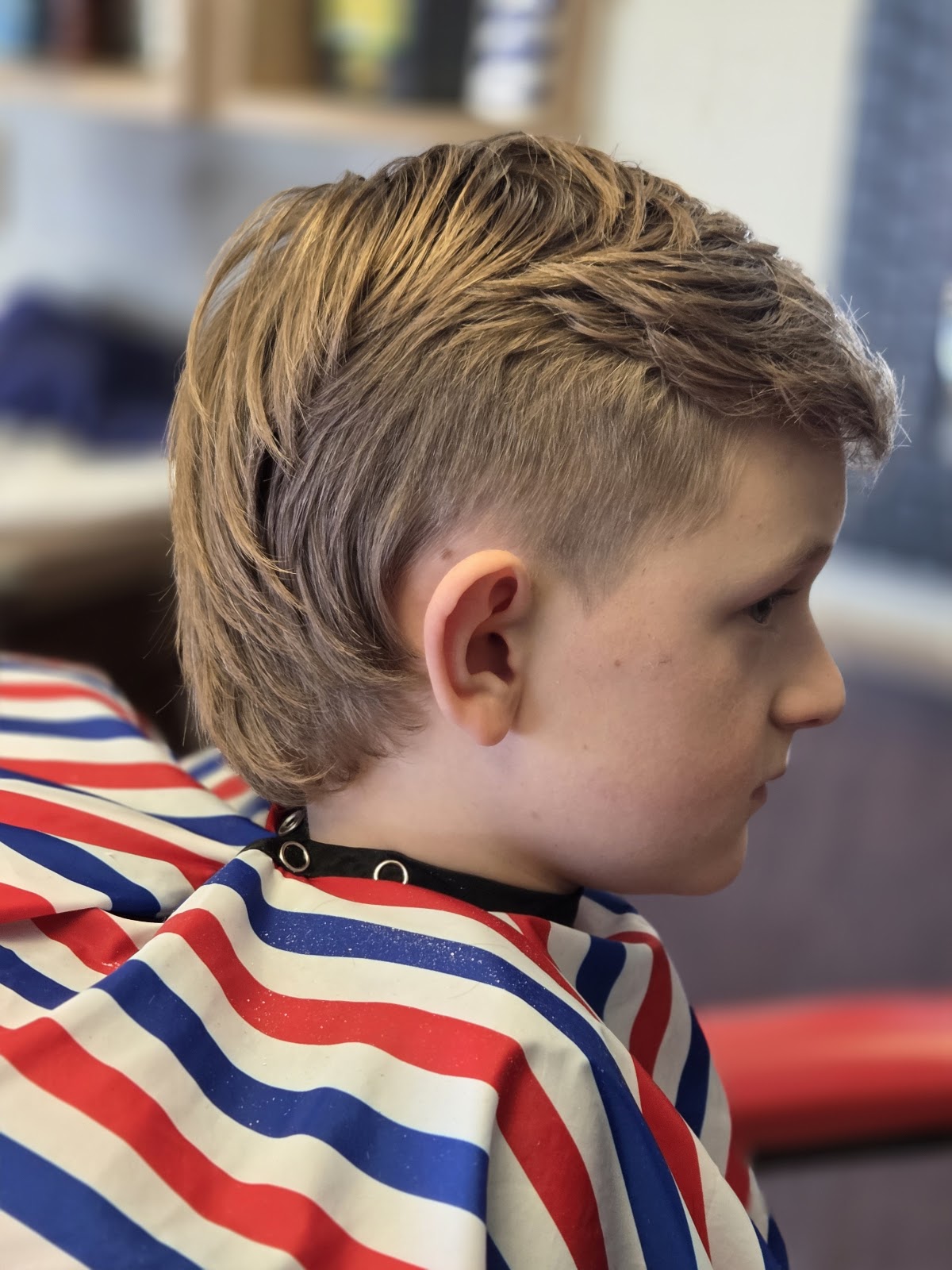Young boy with a fresh haircut at Mike's Barber Shop, showcasing their skill with children