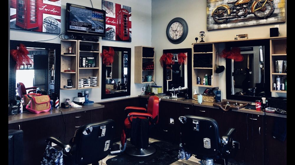 Interior of Mike's Barber Shop showing classic red and black barber chairs with vintage motorcycle art and warm decor