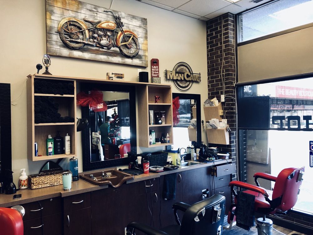 Barber station with vintage motorcycle art and classic red chair at Mike's Barber Shop